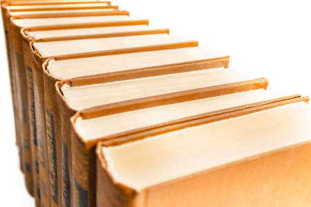 Old books are arranged in a row on white background. perspective view, background, closeup.の写真素材
