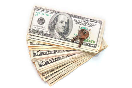 keys and stack of dollars isolated on white backround. Sale and purchase of real estate. Finance,...