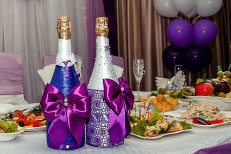 two bottles of champagne in violet decor on a banquette table.の写真素材