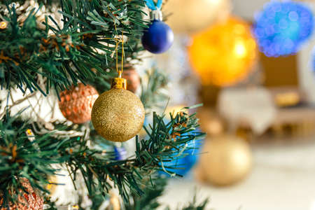 Christmas background - ball on the Christmas tree branch in soft-focus in the backgroundの写真素材