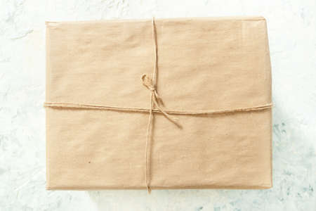 String or twine tied in a box on kraft paper. gift concept. top view.の写真素材