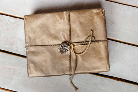 String or twine tied in a box on kraft paper. gift concept. top viewの写真素材