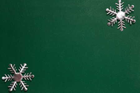 Christmas composition. Christmas frame made of snowflakes on green background. Winter concept. Flat lay, top view, copy spaceの写真素材