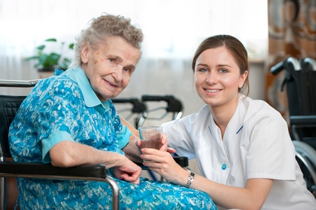 Senior woman with her caregiver at homeの写真素材