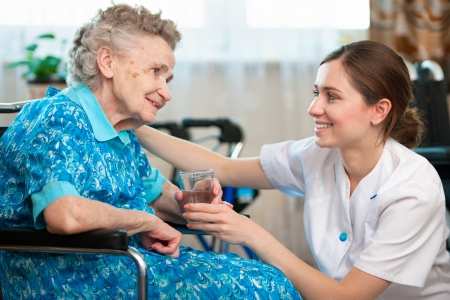 Senior woman with her caregiver at homeの写真素材