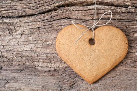 Gingerbread cookies hanging over wooden backgroundの写真素材