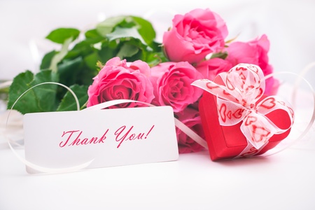 Bouquet of roses and gift box with a cardの写真素材