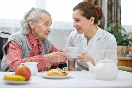 Senior woman eats lunch at retirement homeの写真素材