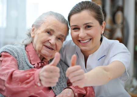 Senior woman and female nurse are showing thumbs upの写真素材