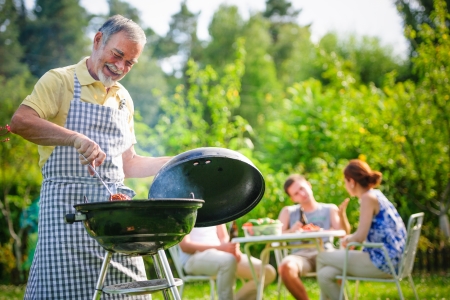 Family having a barbecue party in their garden in summerの写真素材