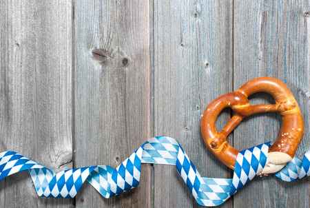 Bavarian pretzels with ribbon on wooden board as a background for Oktoberfestの写真素材