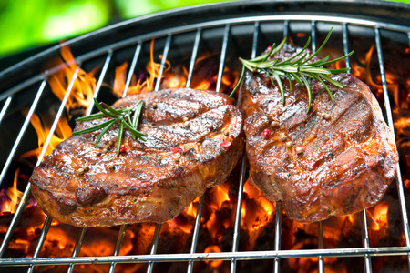 Assorted delicious grilled meat with vegetable over the coals on a barbecueの写真素材