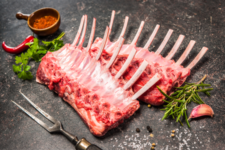 Racks of lamb ready for cooking on dark backgroundの写真素材
