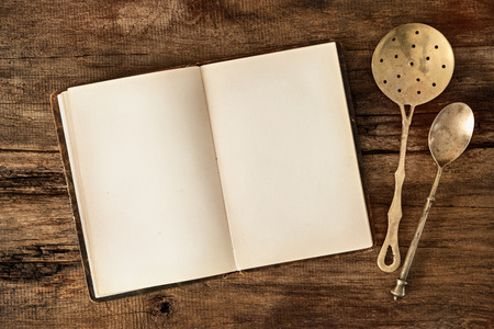 Empty menu or cookbook and vintage kitchen utensils on wooden tableの写真素材