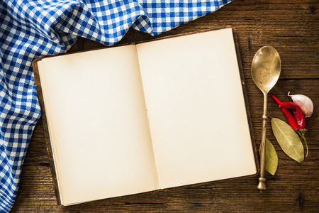 Open cookbook with kitchenware on checkered tableclothの写真素材