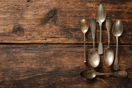Vintage metal spoons on wooden tableの写真素材