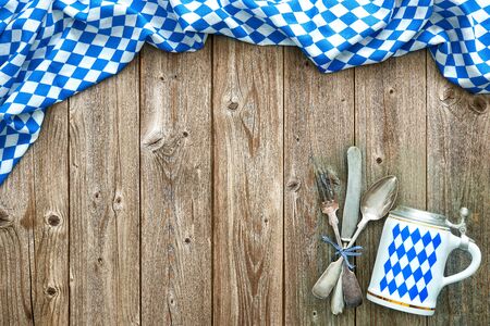 Rustic background for Oktoberfest with Bavarian white and blue fabric, beer stein and silverwareの写真素材