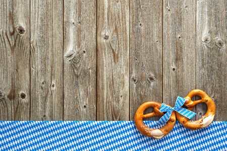 Rustic background for Oktoberfest with Bavarian white and blue fabric and soft pretzelの写真素材