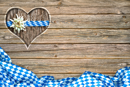 wooden oktoberfest board with heart shaped cut out, bavarian flag and edelweissの写真素材