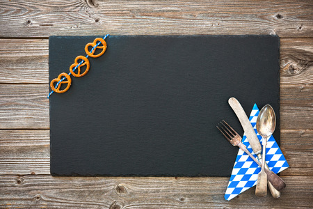 Bavarian silverware and pretzels on wooden board. Background for Oktoberfestの写真素材