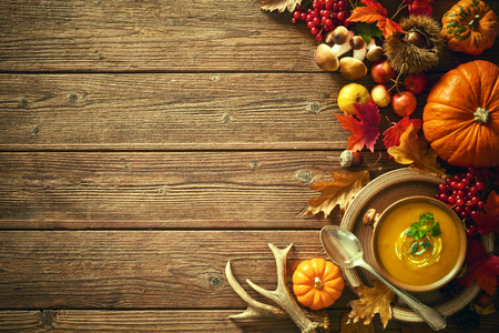 Thanksgiving autumn background with pumpkin soup on a wooden tableの写真素材