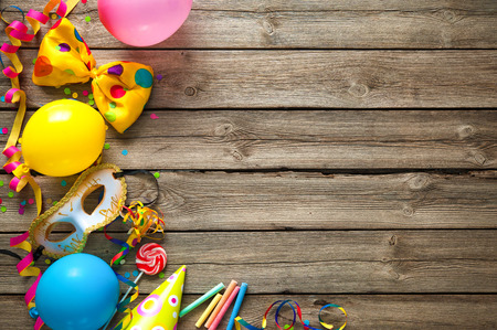 Colorful birthday or carnival frame with party items on wooden backgroundの写真素材