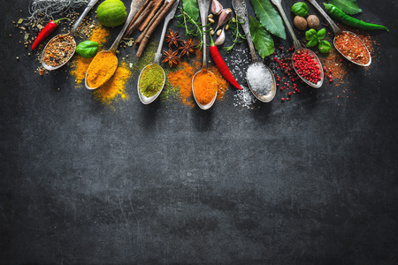 Various herbs and spices on black stone plateの写真素材