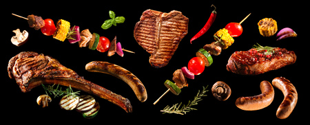 Collage of various grilled meat and vegetables on black backgroundの写真素材