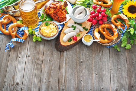 Oktoberfest beer, pretzels and various Bavarian specialties on wooden backgroundの写真素材