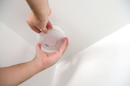 Man installing smoke or carbon monoxide detectorの写真素材