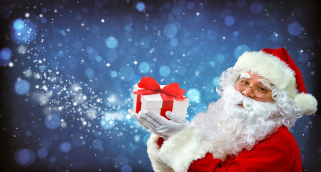 Santa Claus with magic light in his hands. Happy Santa Claus blowing 
Magic Christmas starsの写真素材