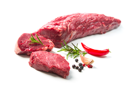 Fresh and raw beef meat. Whole piece of tenderloin with steaks and spices ready to cook isolated on white backgroundの写真素材