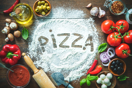 Ingredients and spices for making homemade pizza. Top view with copy space on wooden table の写真素材