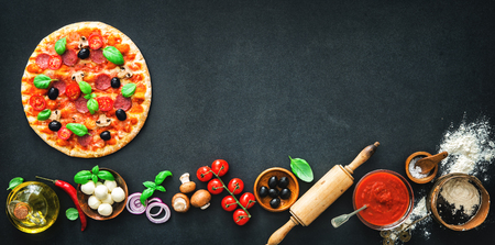 Delicious pizza with ingredients and spices. Top view with copy space on wooden tableの写真素材