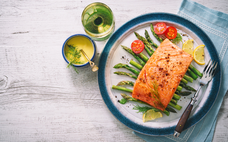 Grilled salmon garnished with green asparagus and tomatoes.Top viewの写真素材