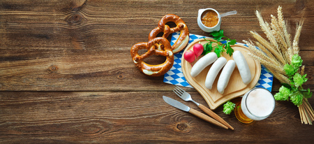Bavarian sausages with pretzels, sweet mustard and beer on rustic wooden table. Oktoberfest menuの写真素材