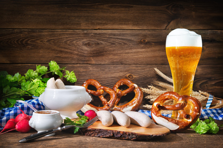 Bavarian sausages with pretzels, sweet mustard and beer on rustic wooden table. Oktoberfest menuの写真素材