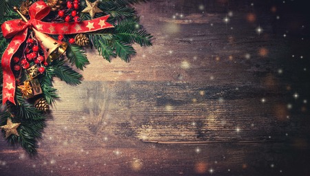 Christmas background with fir tree and decoration on dark wooden board