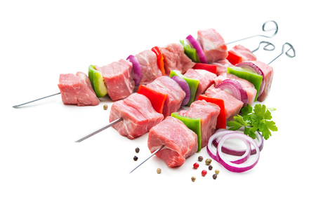 Kebabs - raw meat and vegetables on skewers, ready for grilling. Isolated on whiteの写真素材