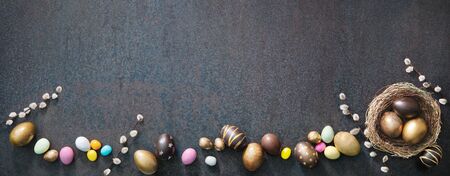 Colorful Easter eggs banner with willow branches on rusticの写真素材