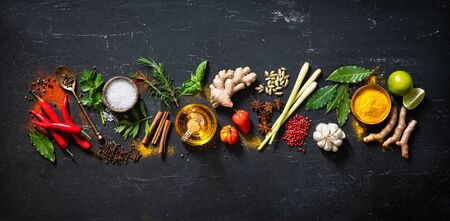 Colourful various herbs and spices for cooking on darkの写真素材