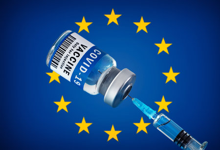COVID-19 vaccine and syringe in front of european flag. Concept of corona virus treatment, injection, vaccination in european unionの写真素材