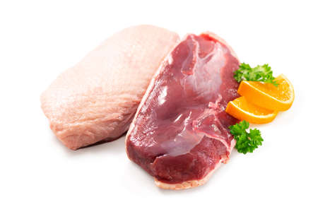 Raw duck breast pieces garnished with parsley and orange slices isolated on white backgroundの写真素材