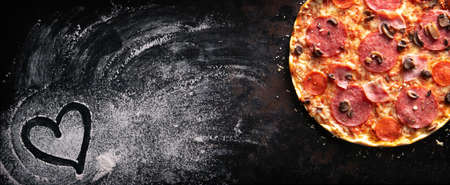 Crispy italian pizza with salami, ham, peppers, cheese and mushroomsの写真素材