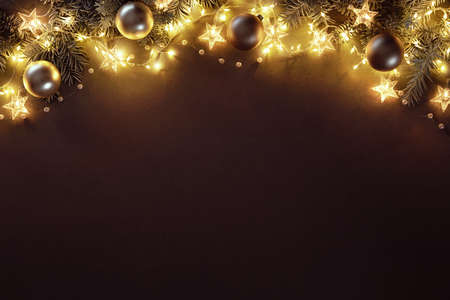 Christmas and New Year background with fir branches, christmas balls and lights on dark boardの写真素材