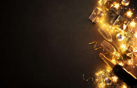 New Years Eve holiday background with fir branches, champagne bottle, christmas balls, gift box and...