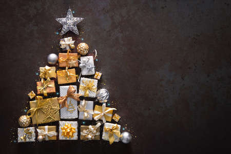 Holidays background with Christmas gift boxes and laid out in the shape of a Christmas tree, top viewの写真素材