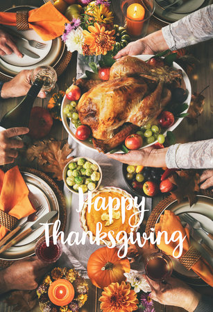 Group of friends or family celebrating together at festive turkey dinner table. Thanksgiving celebration traditional dinner setting meal concept with Happy Thanksgiving textの写真素材