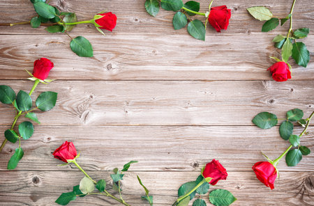 Red roses rustic on wooden board. Top view with copy spaceの写真素材