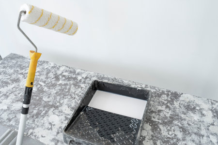 Apartment renovation in a new building. Surface preparation for wallpapering. Surface priming with a roller and antifungal mixtureの写真素材